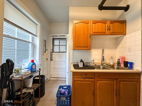 A kitchen with wooden cabinets and a black vacuum cleaner.