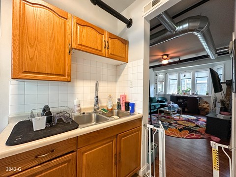 A kitchen with wooden cabinets and a black mat on the counter.