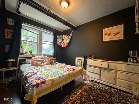 A bedroom with a bed and a dresser.