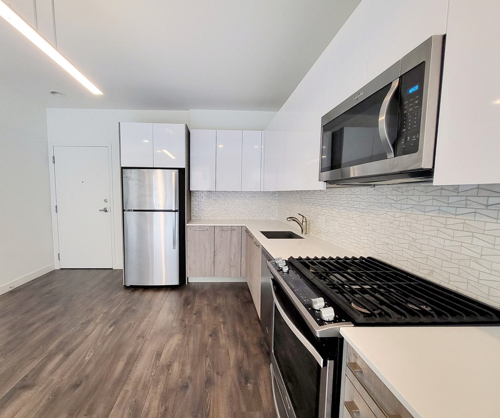 a kitchen with white cabinets and a stainless steel refrigerator