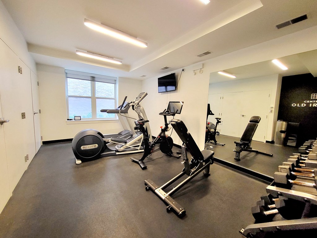 a gym with cardio machines and weights on the floor