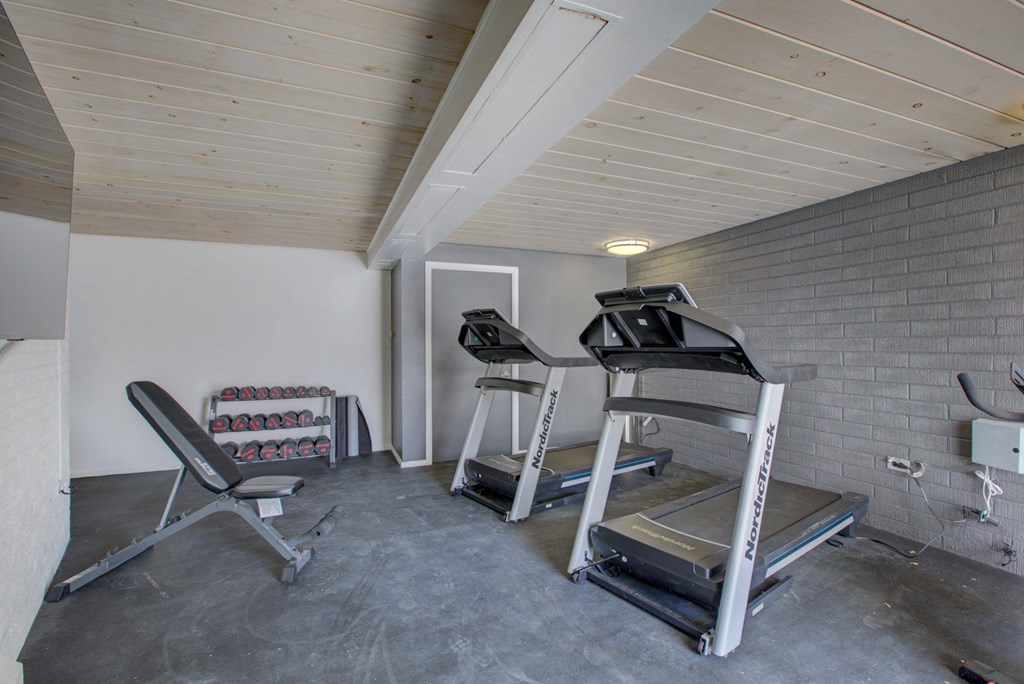 a room with two treadmills and two chairs