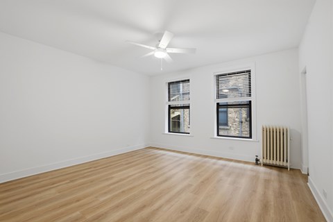 A room with wooden flooring and a ceiling fan.