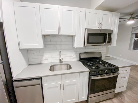 A kitchen with white cabinets and a black stove top oven.