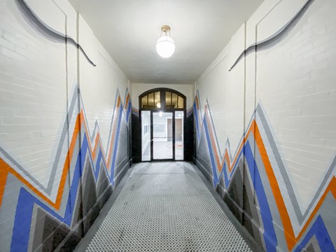 A hallway with a white brick wall and a light on.