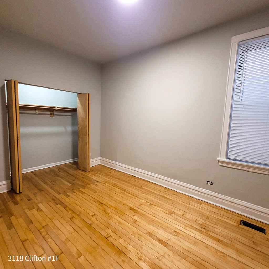 an empty room with wooden floors and a closet