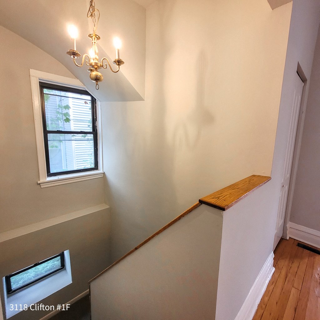 a stairwell in a home with a window and a chandelier