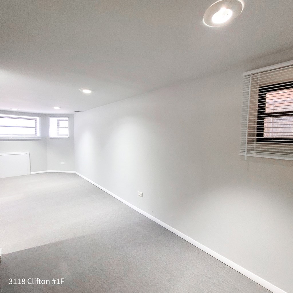 an empty living room with white walls and a window