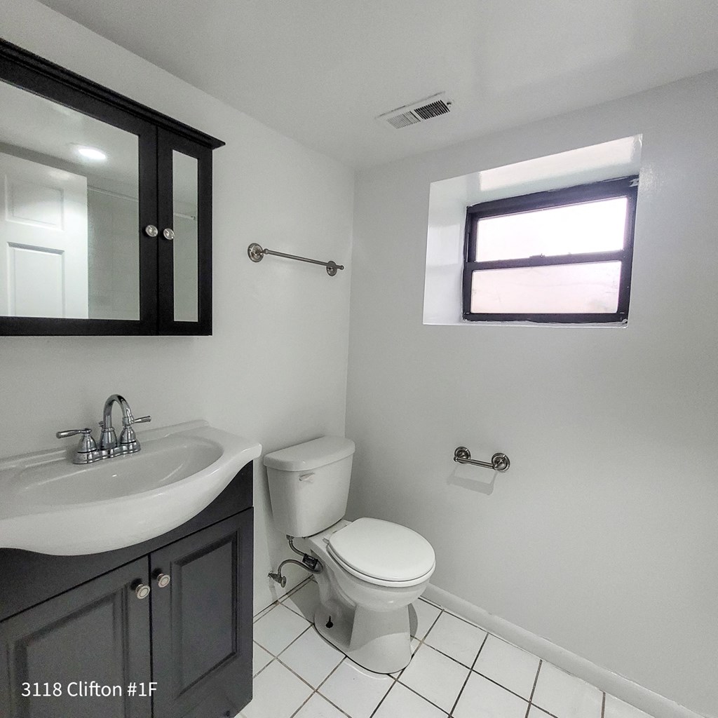 a bathroom with a toilet and a sink and a window