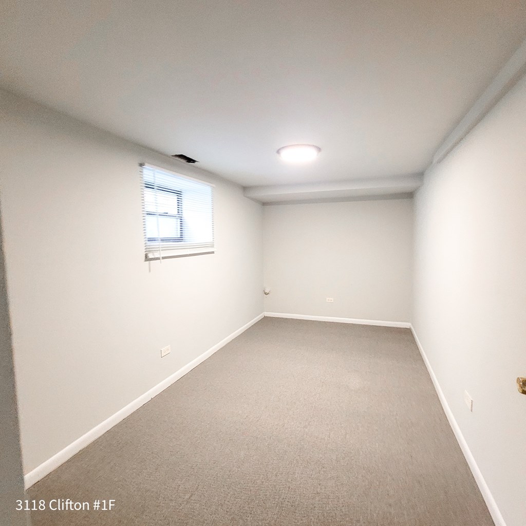 an empty room with white walls and a window