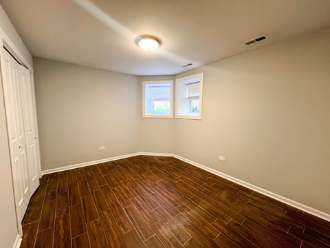 A room with wooden flooring and a window.