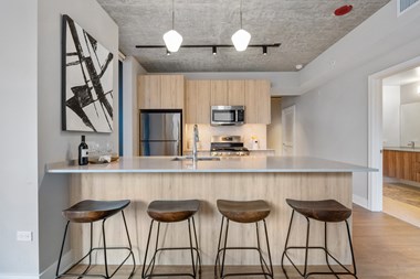 a kitchen with a large island with three stools in front of it