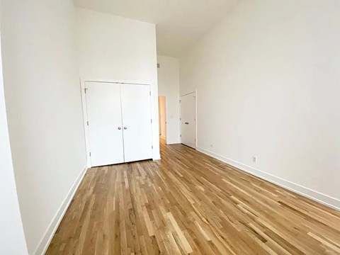 A room with wooden flooring and white walls.