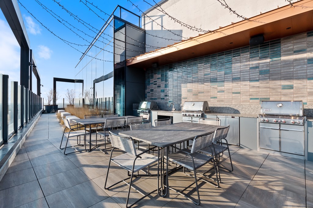 an outdoor terrace with tables and chairs and grilling stations available to the resident's at Avra