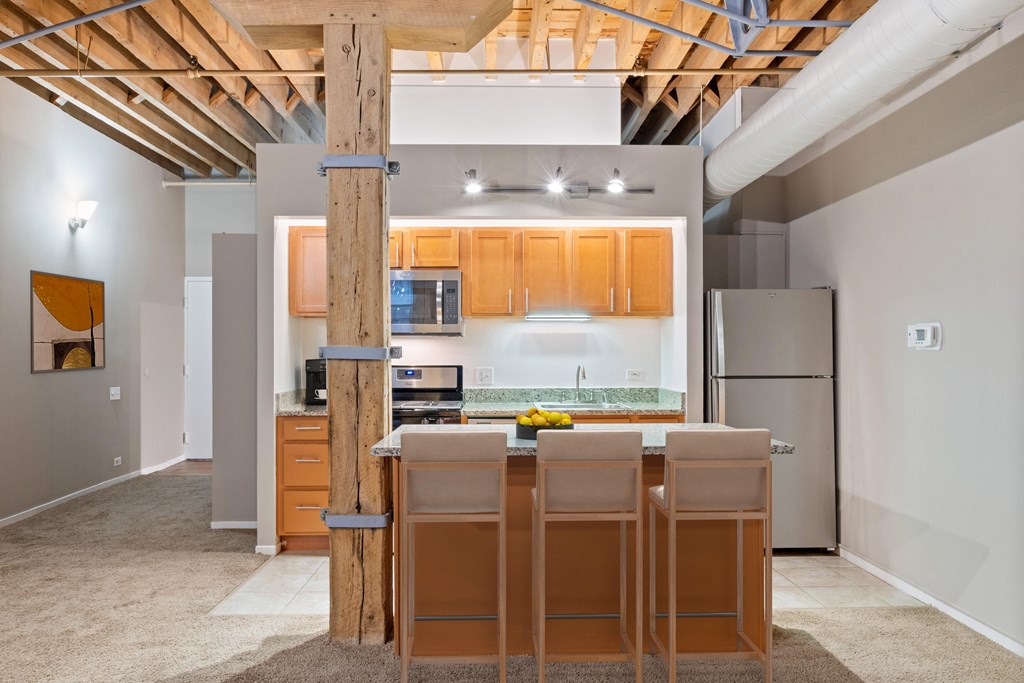 a kitchen with wooden cabinets and a bar with four stools