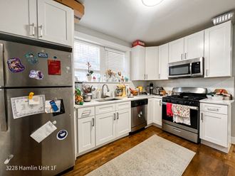 a kitchen with white cabinets and stainless steel appliances