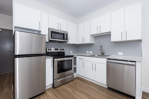 A kitchen with white cabinets and stainless steel appliances.