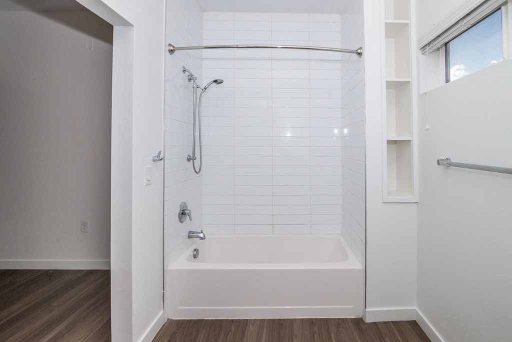 a white bathroom with a shower and a bath tub