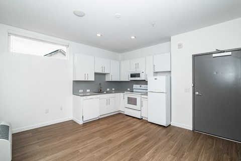A kitchen with white cabinets and a refrigerator.
