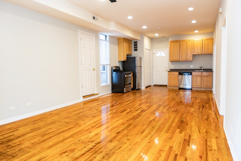 A kitchen with wooden floors and white walls.