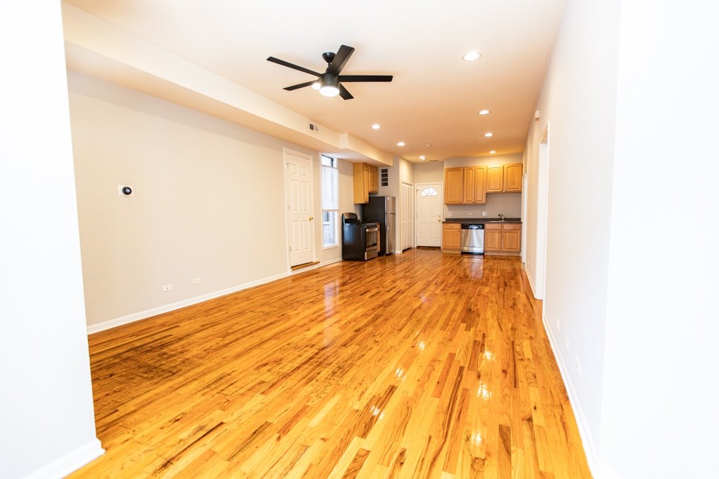 A room with wooden floors and a ceiling fan.