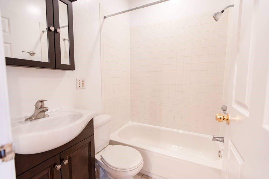 A white toilet sits next to a sink in a bathroom.