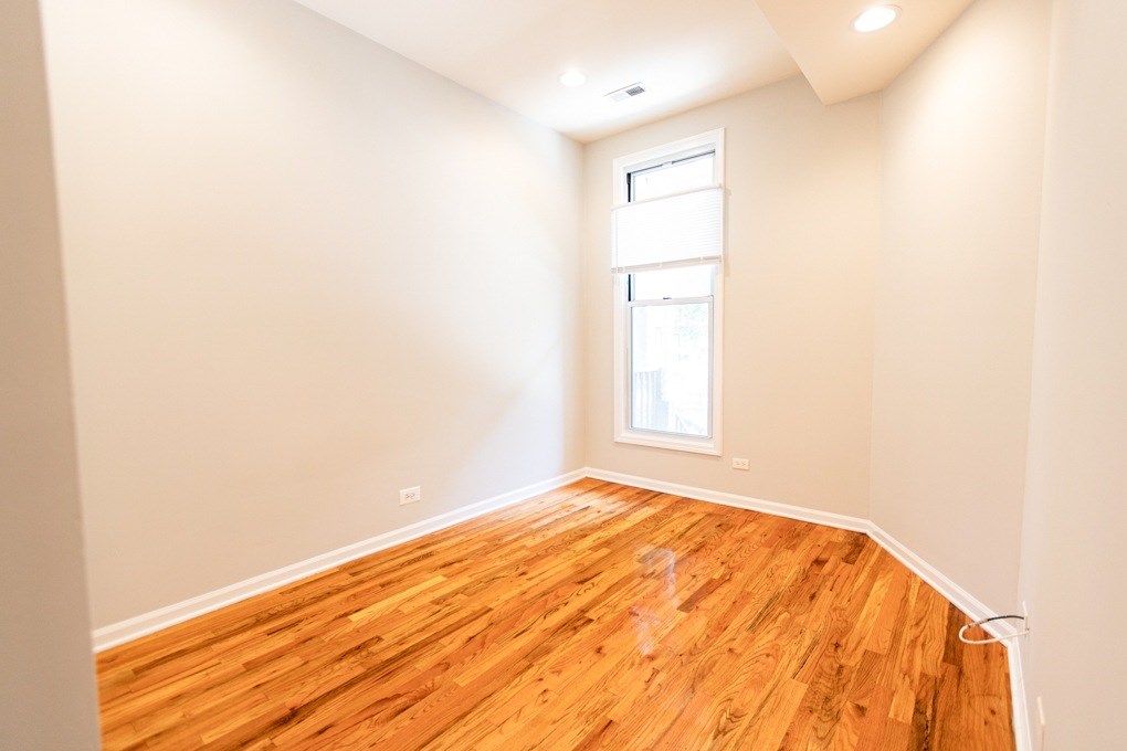 A room with wooden flooring and a window.