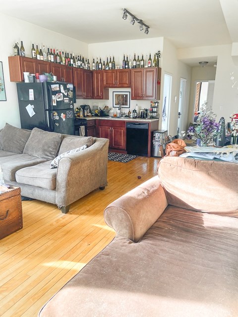 A kitchen with a refrigerator covered in magnets and a dining table with chairs.
