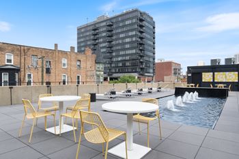 a roof terrace with tables and chairs and a fountain