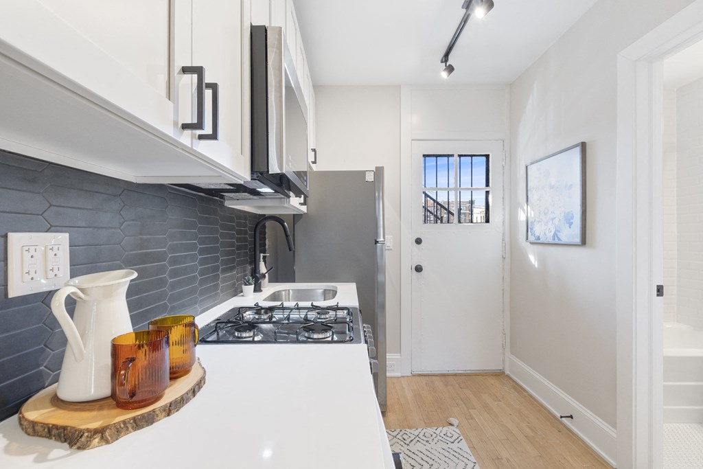 a white kitchen with a stove and a refrigerator