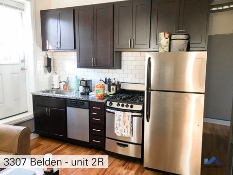 a kitchen with stainless steel appliances and black cabinets
