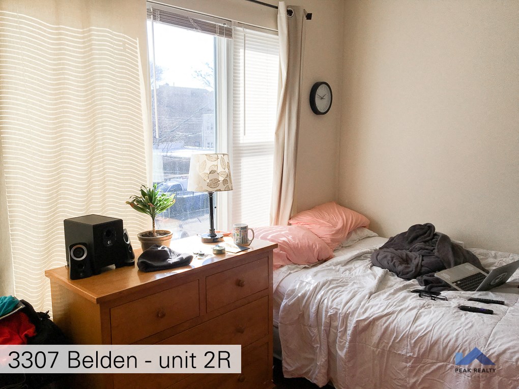 a bedroom with a bed and a dresser and a window