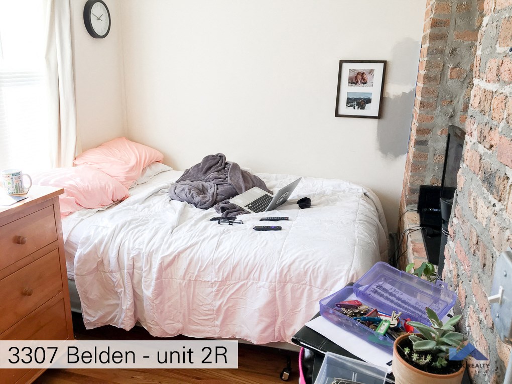 a bedroom with a bed with a laptop on it