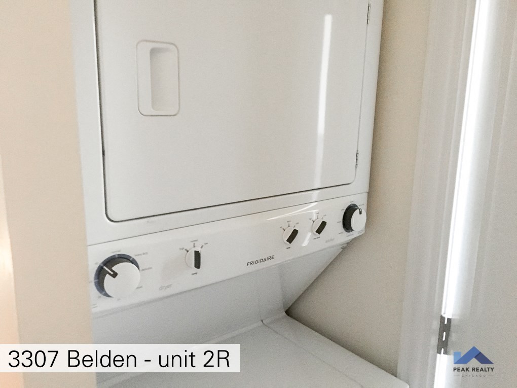 two washers and a dryer in a white room