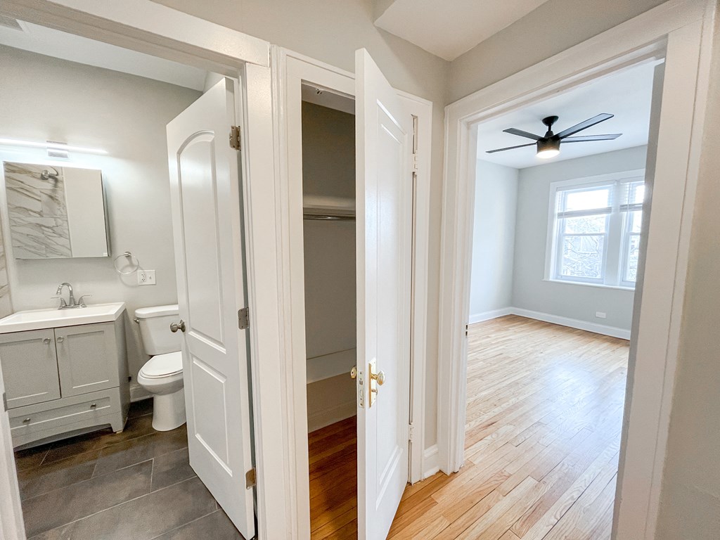an open doorway into a bathroom with a toilet and a closet