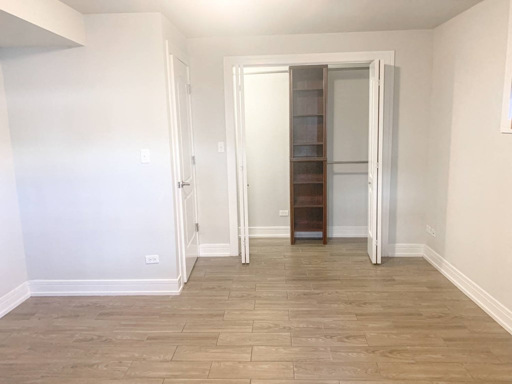 a empty room with a closet and a wooden floor