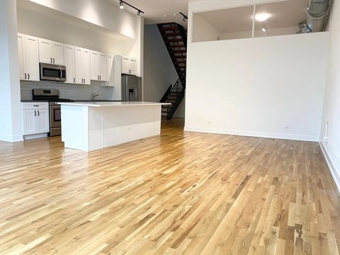 A kitchen with wooden floors and white walls.