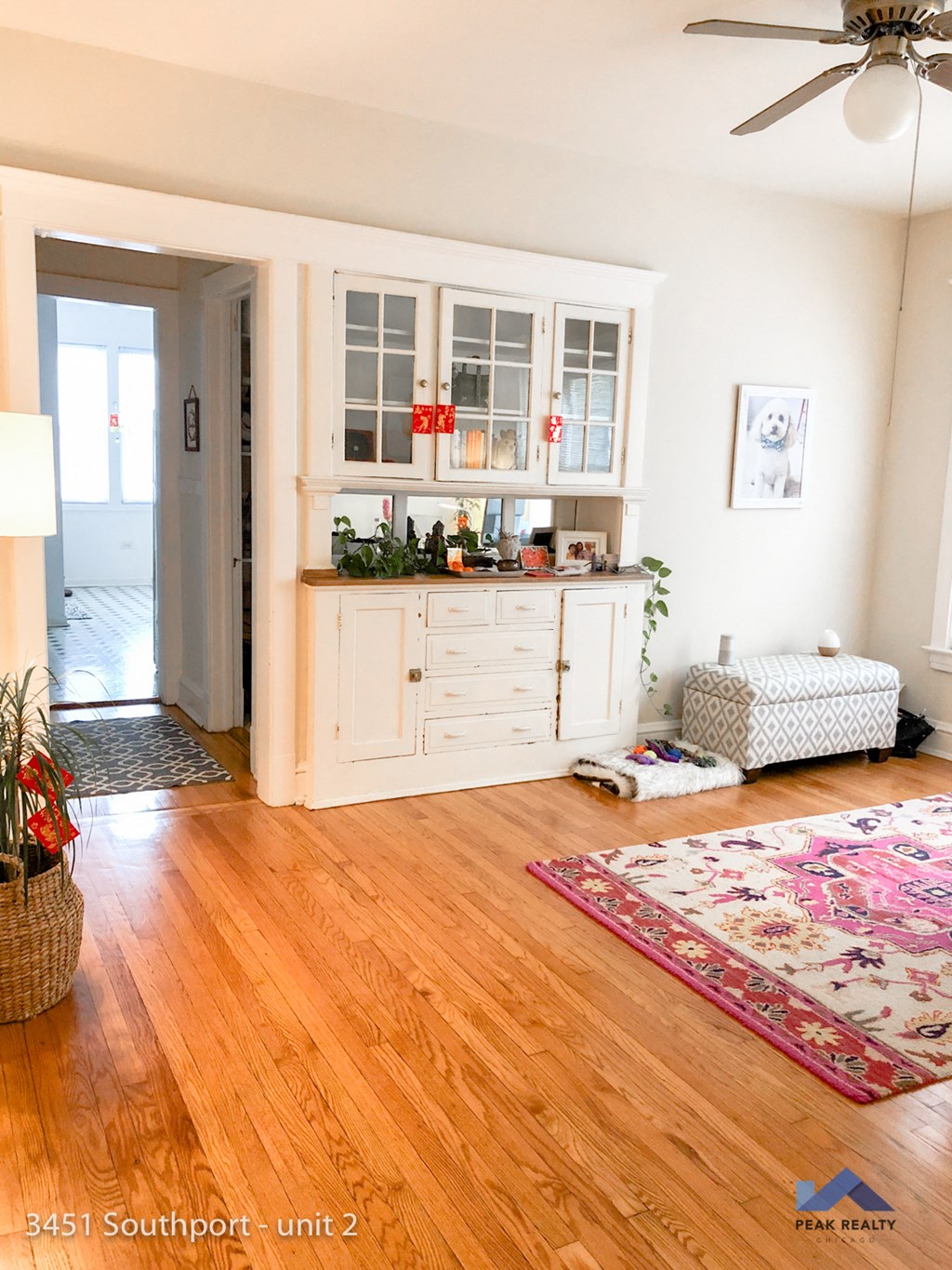 a living room with a wooden floor and a white cabinet