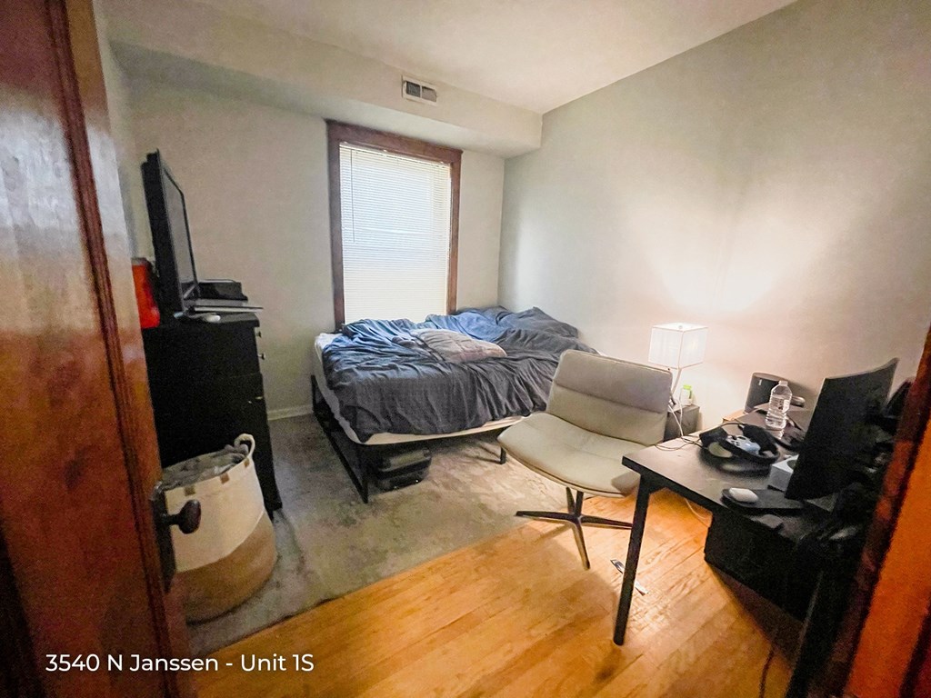 a bedroom with a bed and a desk with a computer