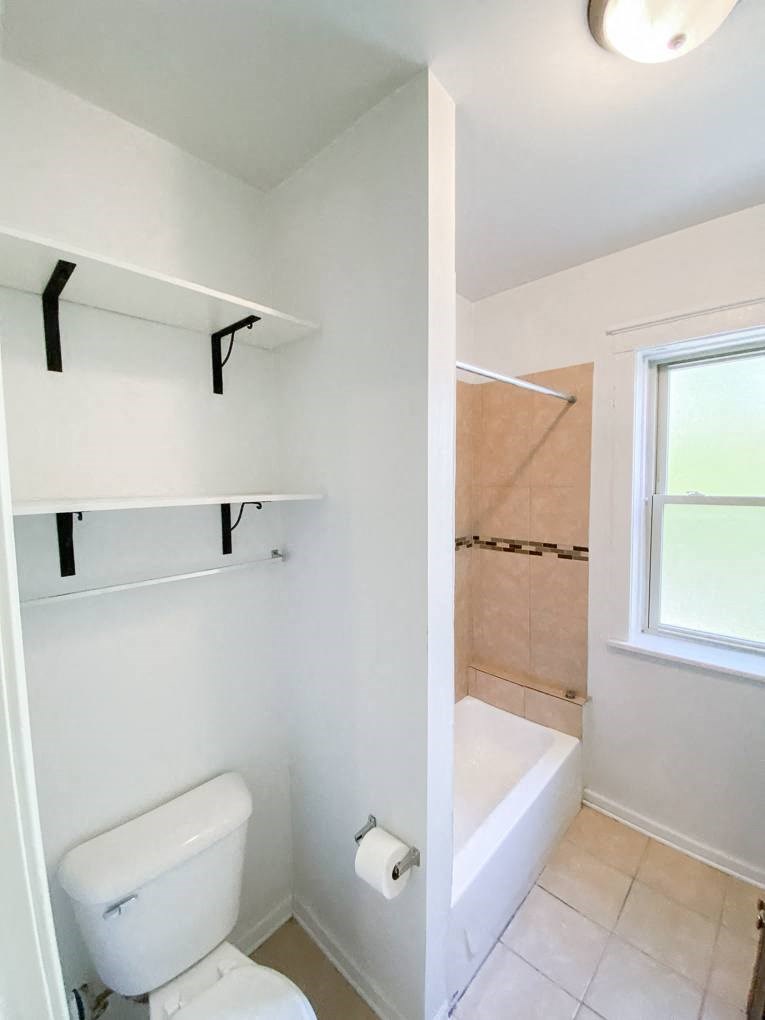 a bathroom with a toilet a bathtub and a window