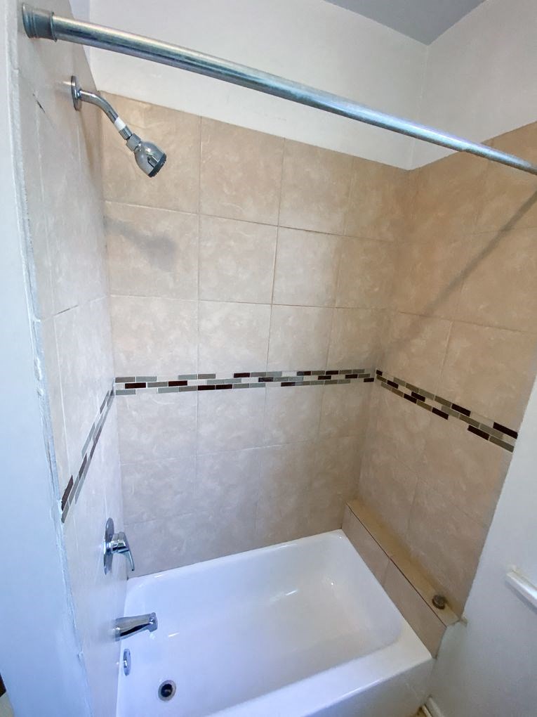a bathroom with a white bathtub and a shower curtain
