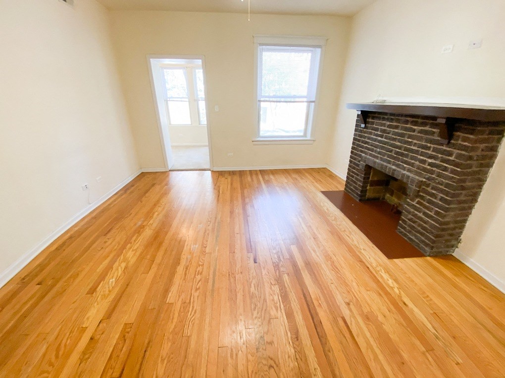 a living room with hardwood floors and a fireplace