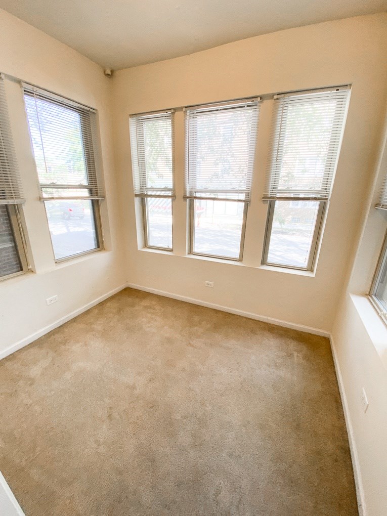 an empty room with four windows and a carpeted floor