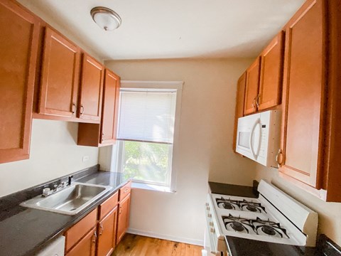 a kitchen with a stove and a sink and a window