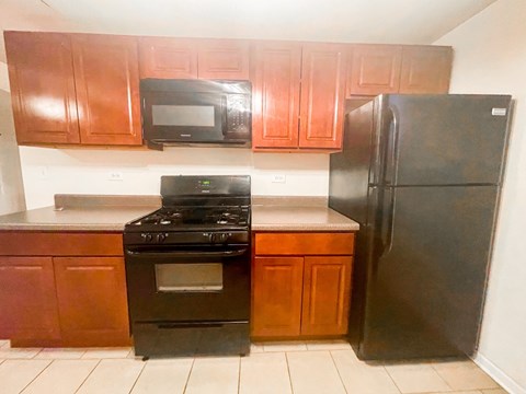 A black stove and oven in a kitchen with brown cabinets.