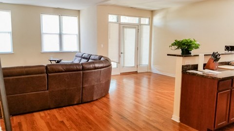a living room with a leather couch and a wooden floor