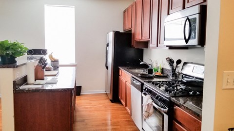 a kitchen with a stove refrigerator and microwave