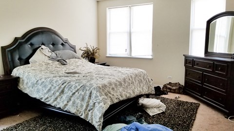 a bedroom with a bed and clothes on the floor