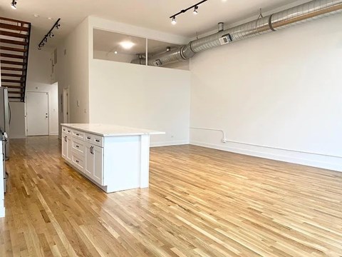 A kitchen with wooden floors and white walls.