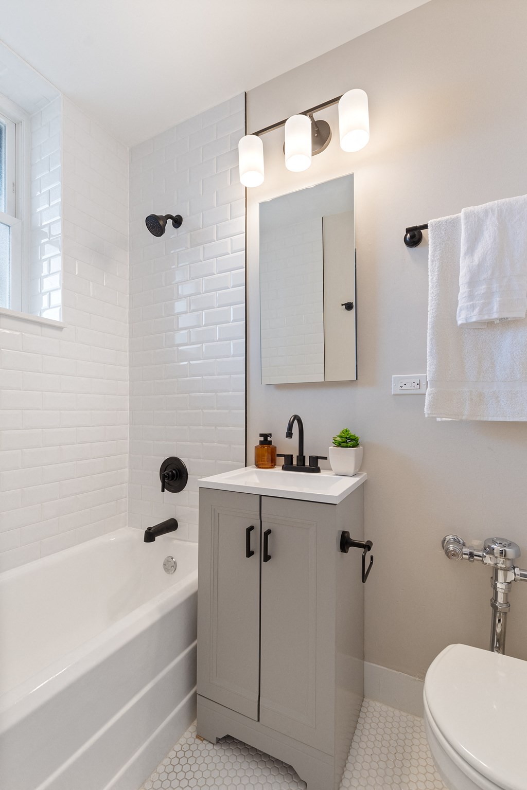 a white bathroom with a sink and a bath tub